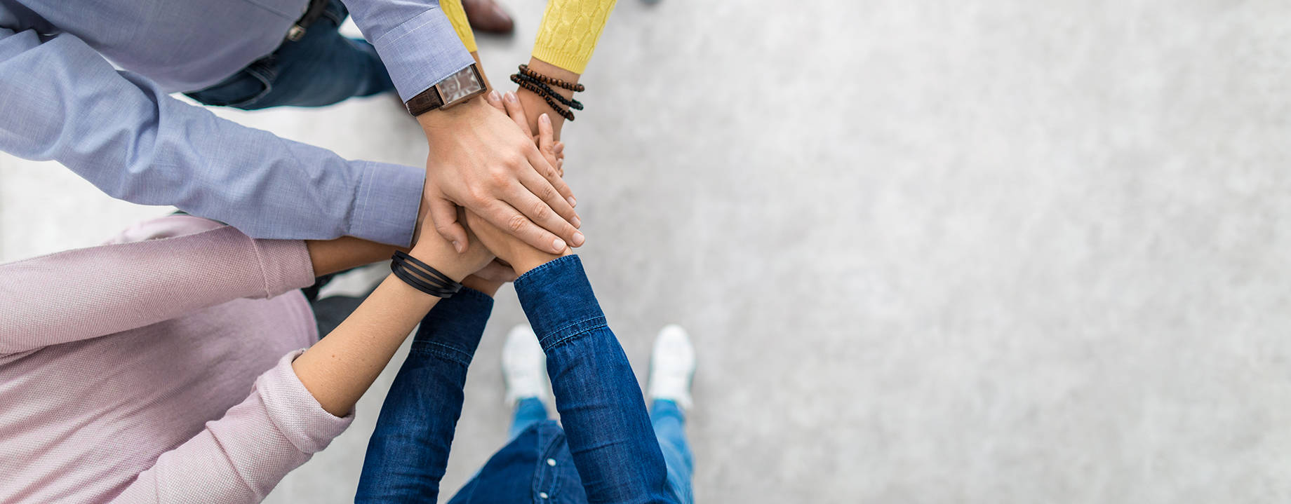 mennesker som legger hendene oppå hverandre